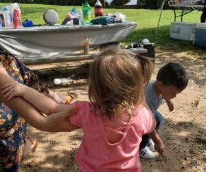 kids digging in dirt at a waterside park area